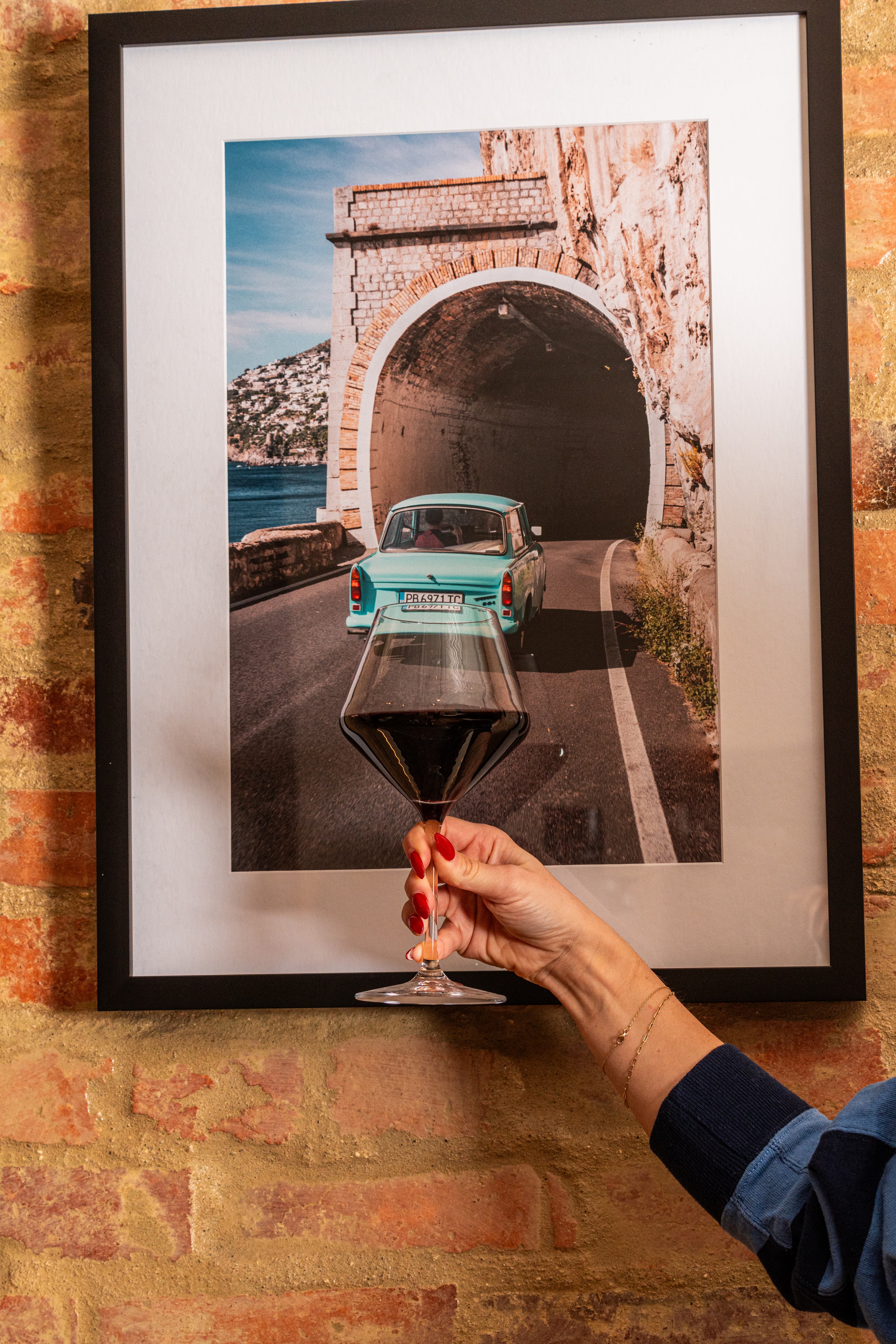 Wine glass in front of Italian art at Ulivo